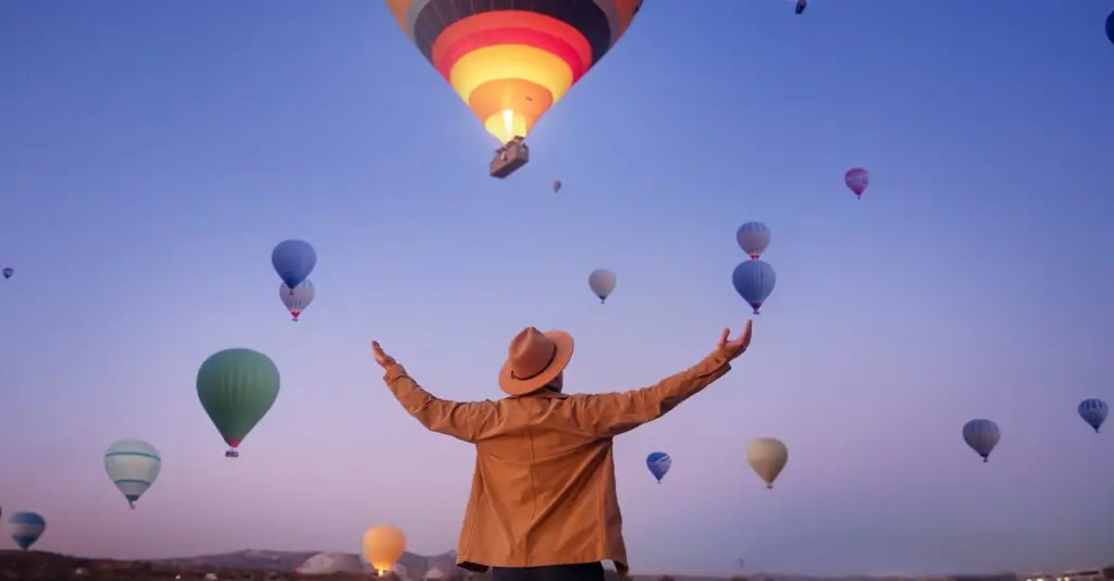man,traveler,arms,outstretched,standing,to,sky,hot,air,balloons