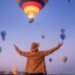man,traveler,arms,outstretched,standing,to,sky,hot,air,balloons