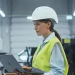 female,machinery,technician,using,laptop,computer,and,programming,a,cnc