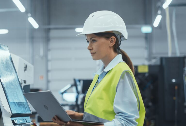 female,machinery,technician,using,laptop,computer,and,programming,a,cnc